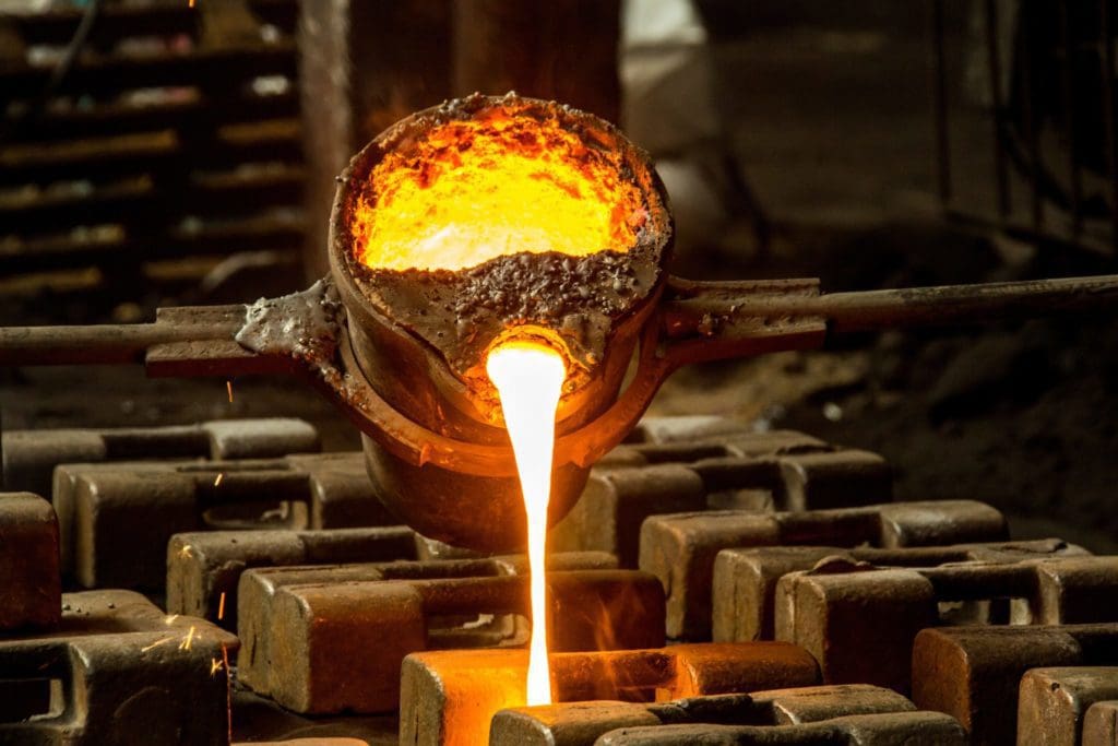 hot molten metal being poured in metal casting mold