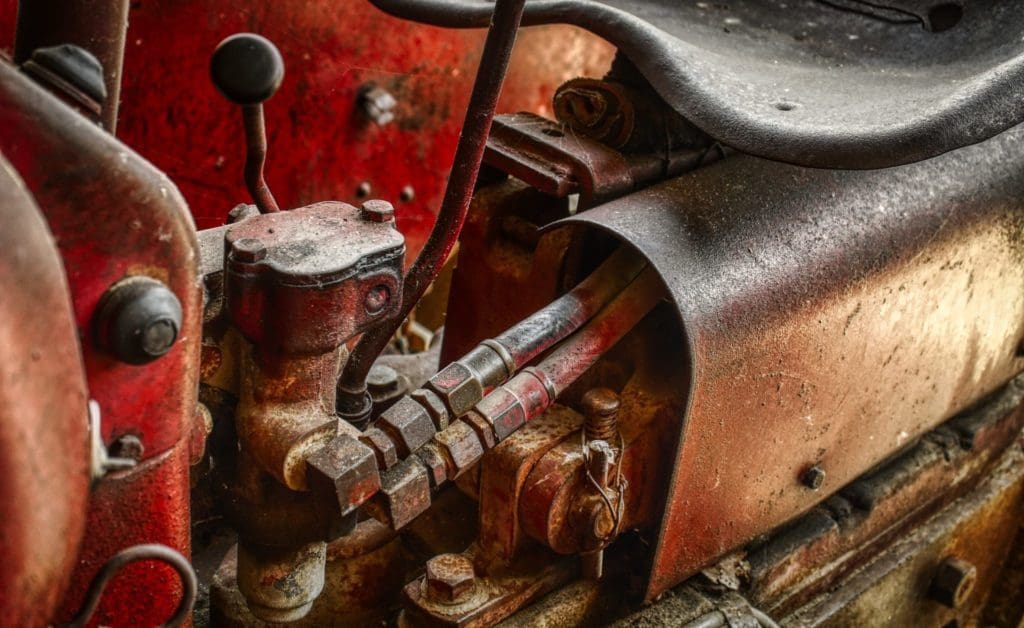 The mechanical workings of an old red tractor