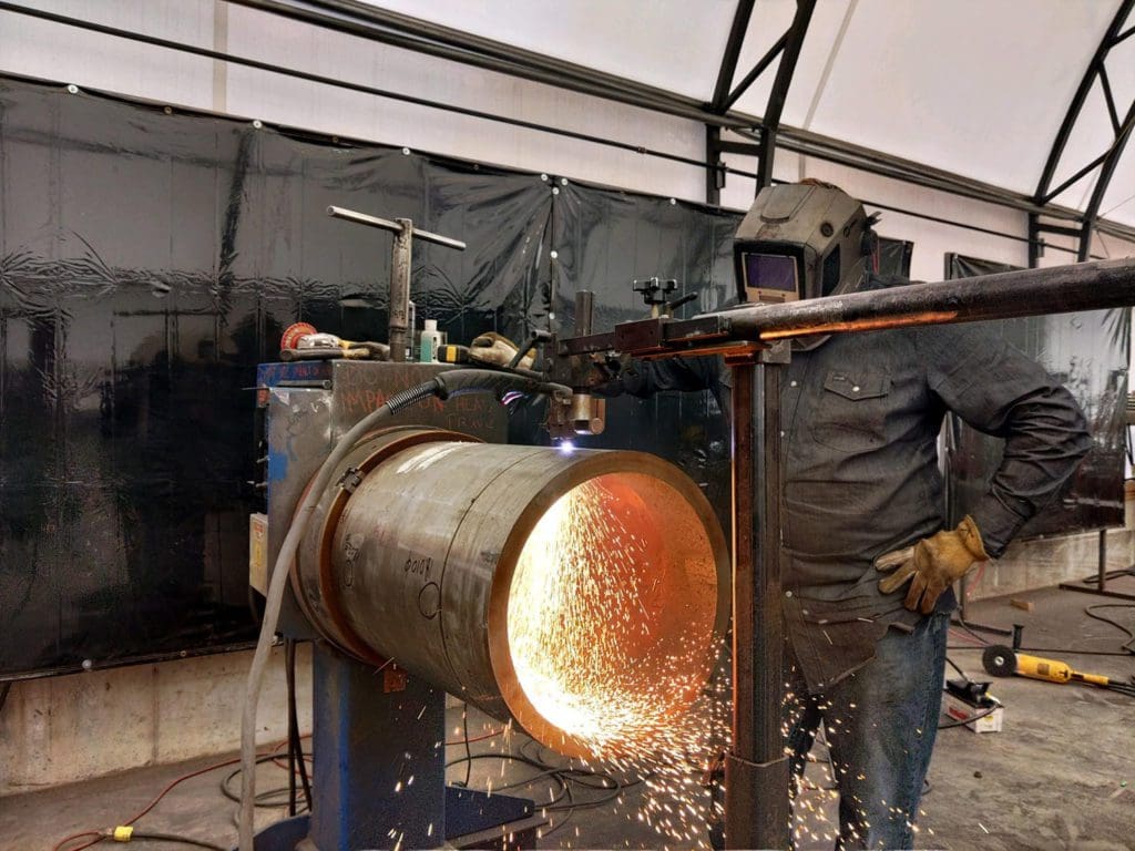 Welder cutting a pipe